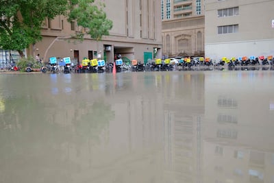 Delivery motorbikes stationed near floodwaters following heavy rains in Sharjah last month. Photo: AFP