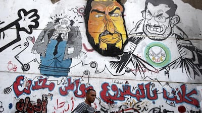 A man walks past graffiti depicting ousted Egyptian President Mohammed Morsi, right, and the Deputy Guide of the Muslim Brotherhood Khairat Al Shater in downtown Cairo, Amr Abdallah Dalsh / Reuters