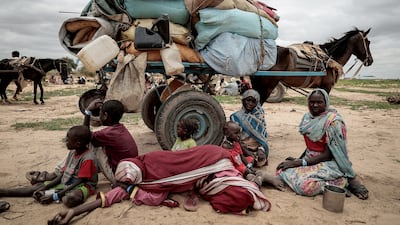A family who fled the war in Sudan's Darfur region wait to be registered by the UN after crossing into Chad. Reuters