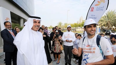 Mashreq employee Nasser Ibrahim, right, who walked 100km along the busy E11 motorway for the Rashid Centre for the Disabled. He was met by Mashreq’s chief executive, Abdul Aziz Al Ghurair, at the finish line. Courtesy Mashreq