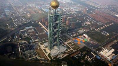 The Hanging Village of Huaxi, a 74-storey tower, consists of three linked structures with a giant glass sphere on the top. Reuters