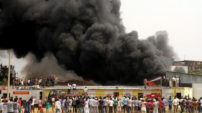 Indian army men and fire fighters try to extinguish flames after a major fire broke out in a scrap dumping ground at Bari Brahmana industrial area near Jammu, India. Jaipal Singh / EPA