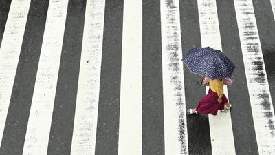 A woman walks in the rain at a pedestrian crossing near Osaka Station as Typhoon Hagibis approaches Osaka, Japan. Reuters