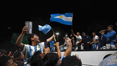 Argentina's players celebrate on board an open-top bus as supporters look on. AFP