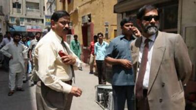 Venu Rajamony, India's consul-general in Dubai, right, and other officials visit the Naif area where 11 men died in a villa fire.