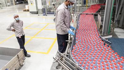 Workers inspect the red-capped Mai Dubai bottles across production lines. Antonie Robertson/The National