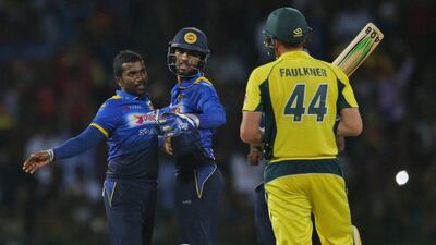 Sri Lanka's Amila Aponso, left, celebrates the dismissal of Australia's James Faulkner with Dinesh Chandimal during their second one-day international cricket match in Colombo, Sri Lanka, Wednesday, August 24, 2016. Eranga Jayawardena / AP Photo