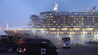 A coach and an ambulance travel towards the Diamond Princess cruise ship, operated by Carnival Corp., docked at dusk in Yokohama, Japan. Bloomberg