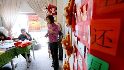 Jenny Tang teaches Mandarin to Zainab Majid, 13, and Ramzi Sharif, 17, at her flat in Abu Dhabi. Mrs Tang also teaches Mandarin at Zayed University, which will be home to the Confucius Institute.