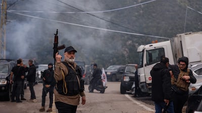 A man fires an AK-47 in the air during the funeral of Pierre Mouawad and his wife Flavia in Yahchouch. Their killing highlighted sectarian tension in Lebanon. AFP