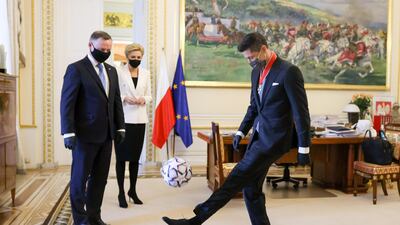 Robert Lewandowski kicks a ball as Poland's President Andrzej Duda and First Lady Agata Kornhauser-Duda look on after the award ceremony. Reuters