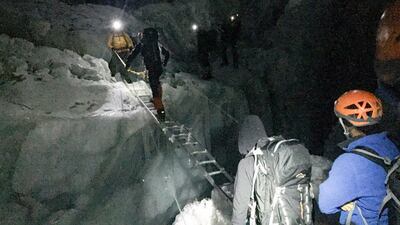 Members of the Armed Forces cross a crevasse in the Khumbu Icefall.