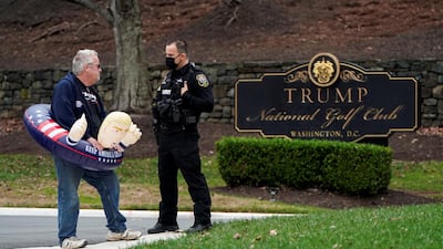 A supporter of U.S. President Donald Trump speaks to a police officer as he waits for Trump to depart the Trump National Golf Club in Sterling, Virginia. Reuters
