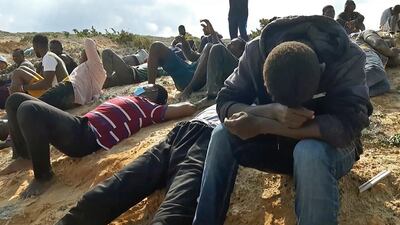 Migrant survivors of a deadly shipwreck sit on a sandy beach on the coast of al-Khums, a port city 120 kilometres west of the Libyan capital Tripoli. AFP