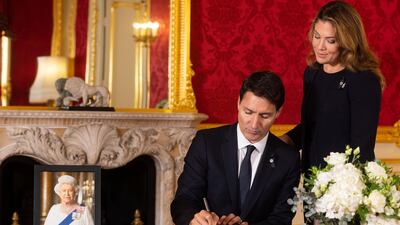 Prime Minister of Canada Justin Trudeau signs a book of condolence for Queen Elizabeth as his wife Sophie looks on. AP