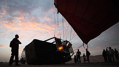Hot air balloon pilot Peter Kollar, of Balloon Adventures Emirates, fills a balloon with hot air in the early morning desert light yesterday.