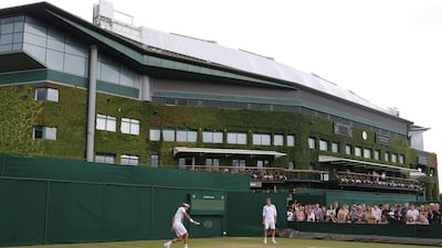Roger Federer is pictured rallying during a training session with his coach Stefan Edberg, to his right, on Saturday ahead of Sunday's 2014 Wimbledon men's singles final against Novak Djokovic. Andrew Cowie / AFP