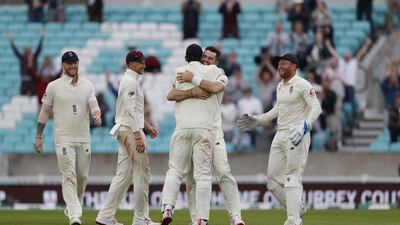 England's James Anderson, centre, celebrates with teammate Alastair Cook after taking the wicket of India's Mohammed Shami. AFP