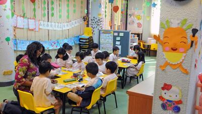 A teacher guiding children during a lesson in Singapore. Singapore has consistently been among the top performing countries in global education league tables and was once touted by the Organisation for Economic Cooperation and Development as a ‘poster child’ for education development. Roslan Rahman/AFP Photo