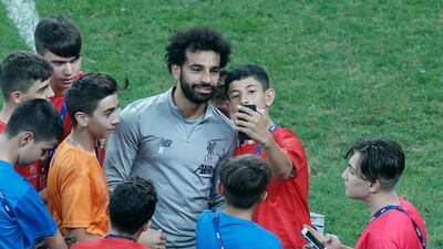 Liverpool's Mohamed Salah, poses for photos with children following a training session at the Besiktas Park Stadium, in Istanbul. AP Photo