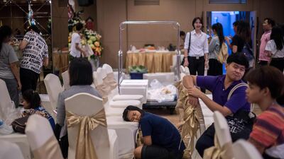 A girl sleeps on a chair as others put together elaborate fruit and vegetable displays during a fruit and vegetable carving competition in Bangkok. Robert Schmidt / AFP