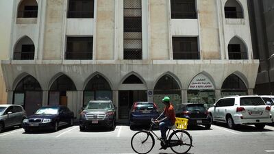 A man bikes past affordable apartments near the Abu Dhabi Corniche (DELORES JOHNSON / The National )