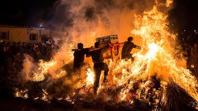 Men carrying a shrine jump over a bonfire, which means a wish for good luck during a traditional Chinese lunar new year celebration in Jieyang, Guangdong province, China. China Daily / via Reuters