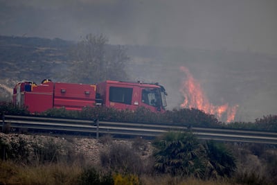 A firefighter truck next to flames in the area of a wildfire that killed 12 near Bedar, in Los Gallardos district, Almeria Province. AFP