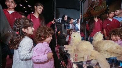 Girls in awe of the interactive cat which helps trauma victims heal through touch. Victor Besa for The National.