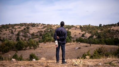 A migrant stands on a hill at an abandoned army outpost near Ieropigi village, northern Greece, at the Greek - Albanian border.