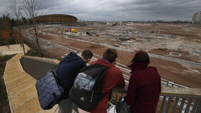 In this February 23, 2014 photo, people take a look at the construction site in Queen Elizabeth Olympic Park in east London. The Games’ Velodrome is seen left. London continues to bask in the success of the most recent Summer Games, but the Olympic legacy is difficult to determine. The flagship venue, renamed the Queen Elizabeth Olympic Park, is being converted into a massive park as big as London’s famous Hyde Park, complete with wildlife habitats, woods and sports facilities. The first part of the ambitious project will begin to open to the public in April. The 80,000-seat Olympic Stadium at the center of the park has been troubled by controversy since even before the games, and its post-games use was the subject of months of legal wrangling. The stadium is now being converted into a soccer venue and the home of the West Ham soccer club, with an expected price tag of $323 million. Many argue taxpayers should not have to fund a Premier League club, though officials insist that the stadium will continue to host other major sporting events, including the Rugby World Cup in 2015. Lefteris Pitarakis / AP Photo