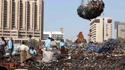 Workers remove burnt goods from the charred remains of two cargo boats, recently gutted on Dubai Creek.