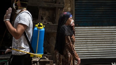 A woman covers her face during a civil initiative to sterilise garbage collectors' neighbourhood of 'The Zebaalin' to help stop the spread of coronavirus at Cairo, Egypt. EPA