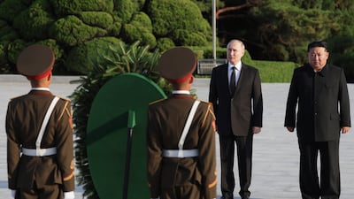 Mr Putin and Mr Kim attend a wreath-laying ceremony at Liberation Monument in Pyongyang. EPA / Sputnik