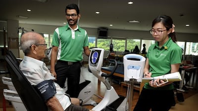 Staff nurses attend to an elderly patient doing rehab excercises at the Ren Ci Community Hospital in downtown Singapore. Munshi Ahmed for The National