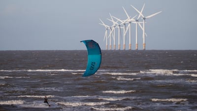 A kite-surfer rides the waves in front of the Burbo Bank offshore wind farm near Wallasey, Britain. Reuters