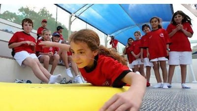 Students practice surfing during health day at Jebel Ali Primary School in Dubai yesterday. Pawan Singh / The National