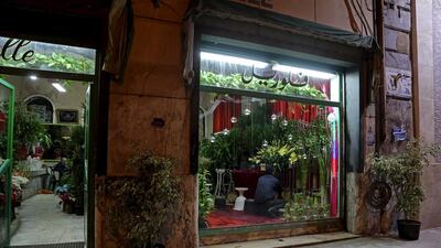 A worker arranges flowers inside the oldest florist on Fouad street.