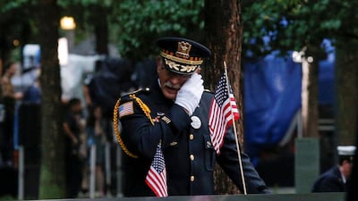 A guest wipes a tear among names at the edge of the south reflecting pool at the National 9/11 Memorial and Museum. Reuters