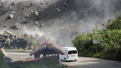Boulders tumble down a hillside as a minibus negotiates a bend in the road during an earthquake in Bauko, Mountain Province, Philippines. One passenger was injured when a boulder hit the vehicle. AP Photo
