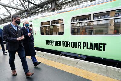 Britain's Prince Charles, Prince of Wales (right) walks alongside a hydrogen powered train with Martin Frobisher, from Network Rail group. AFP