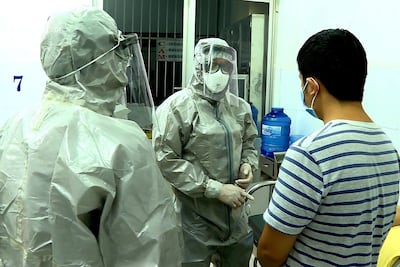 Officials from Vietnam's Ministry of Health talk to a man tested positive for the Wuhan coronavirus, at an isolated section at Cho Ray hospital, in Ho Chi Minh city, Vietnam. EPA