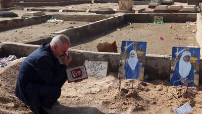 Mohammed Al Qurayshi praying by the graves of his two daughters, Fatima, 14, left, and Rosul, 15, right, who were electrocuted to death during flooding in Iraq. The Iraqi ministry of health said 69 people have died across the country over the past two weeks, due to a combination of the country’s dilapidated electrical grid and heavy rains that overwhelmed sewer systems. Hadi Mizban/AP Photo