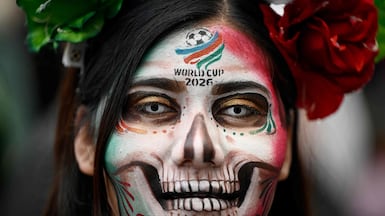 A woman with her face painted takes part in a procession of Catrinas wearing the Mexican World Cup national football team jersey in Mexico City. AFP