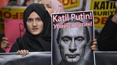 A demonstrator holds a picture depicting Russian president Vladimir Putin during a protest against Russian military operations in Syria, in Istanbul, Turkey. The picture reads both in Turkish and Russian: ‘Murderer Putin’, as Moscow ramps up its military involvement in Syria’s civil war. AP Photo