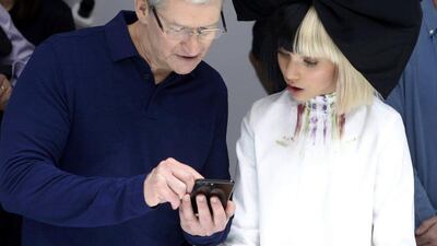 Apple CEO Tim Cook shows singer Sia an iPhone 7. Beck Diefenbach / Reuters