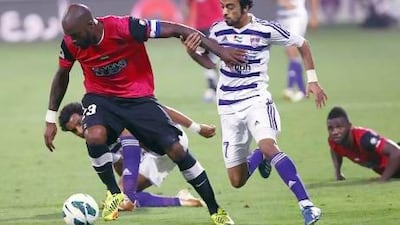 Al Ahli's Grafite, left, and Al Ain's Ali Al Wehaibi tussle for the ball. Satish Kumar / The National