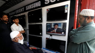 Men in Karachi watch a televised speech by Prime Minister Imran Khan after Pakistan shot down two Indian military aircraft. Reuters/Akhtar Soomro