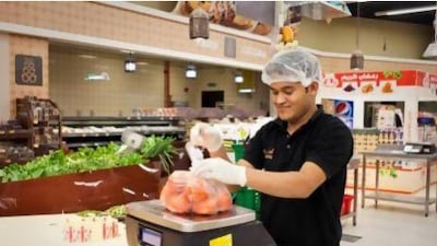 A member of staff at work at Aswaaq in Mizhar, which is ranked the 12th best company to work for in the UAE. Razan Alzayani / The National