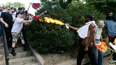 A counter demonstrator uses a lighted spray can against a white nationalist demonstrator at the entrance to Lee Park in Charlottesville. Steve Helber / AP/